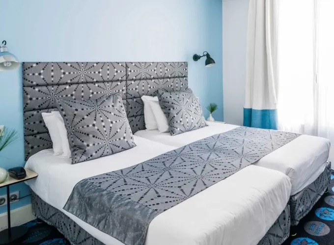 Chambre Twin avec deux lits et un mur bleu à l’hôtel Astoria