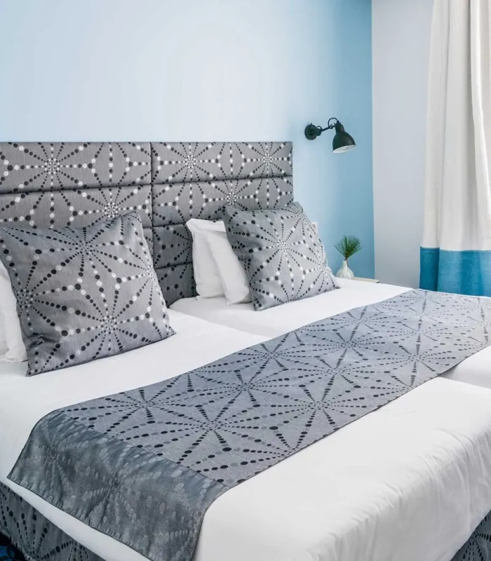Chambre Twin avec deux lits et un mur bleu à l’hôtel Astoria