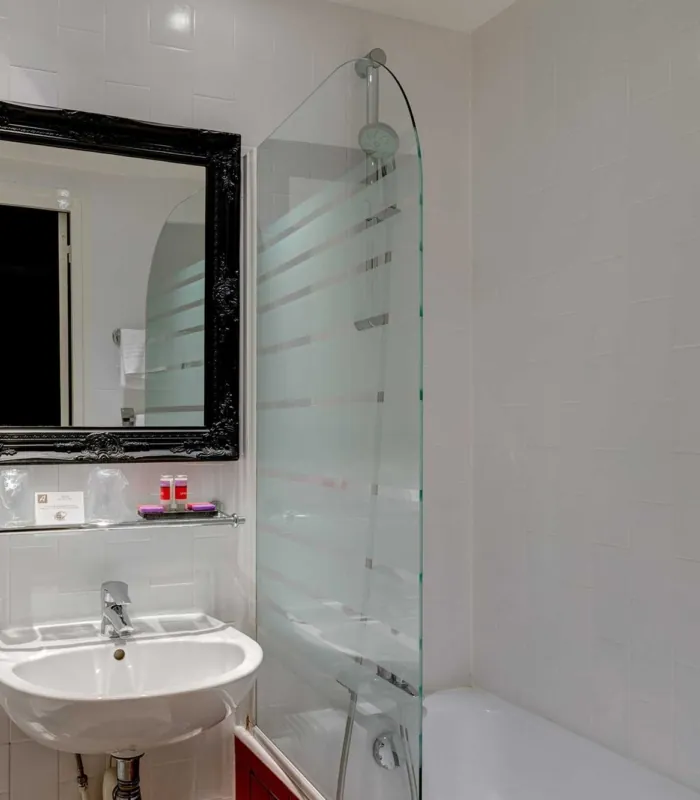 Salle de bain de la Chambre Twin Supérieure avec un lavabo, un miroir et une baignoire à l’hôtel Astoria