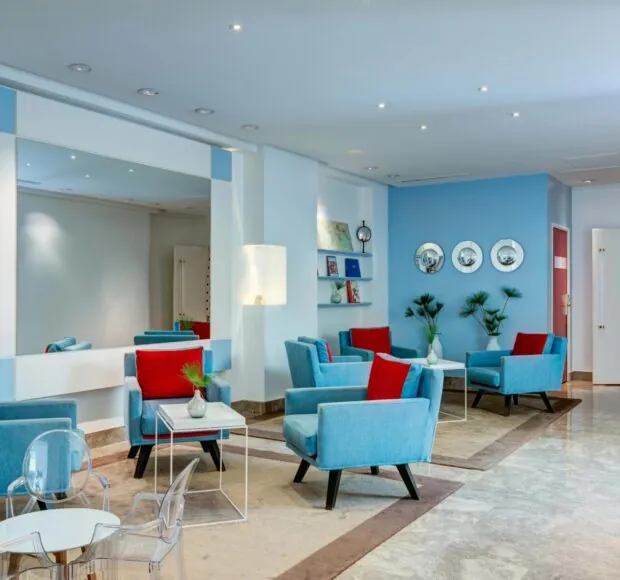 Vue du lobby de l’hôtel 3 étoiles Astoria à Paris, où des couleurs élégantes se marient parfaitement à une atmosphère raffinée.