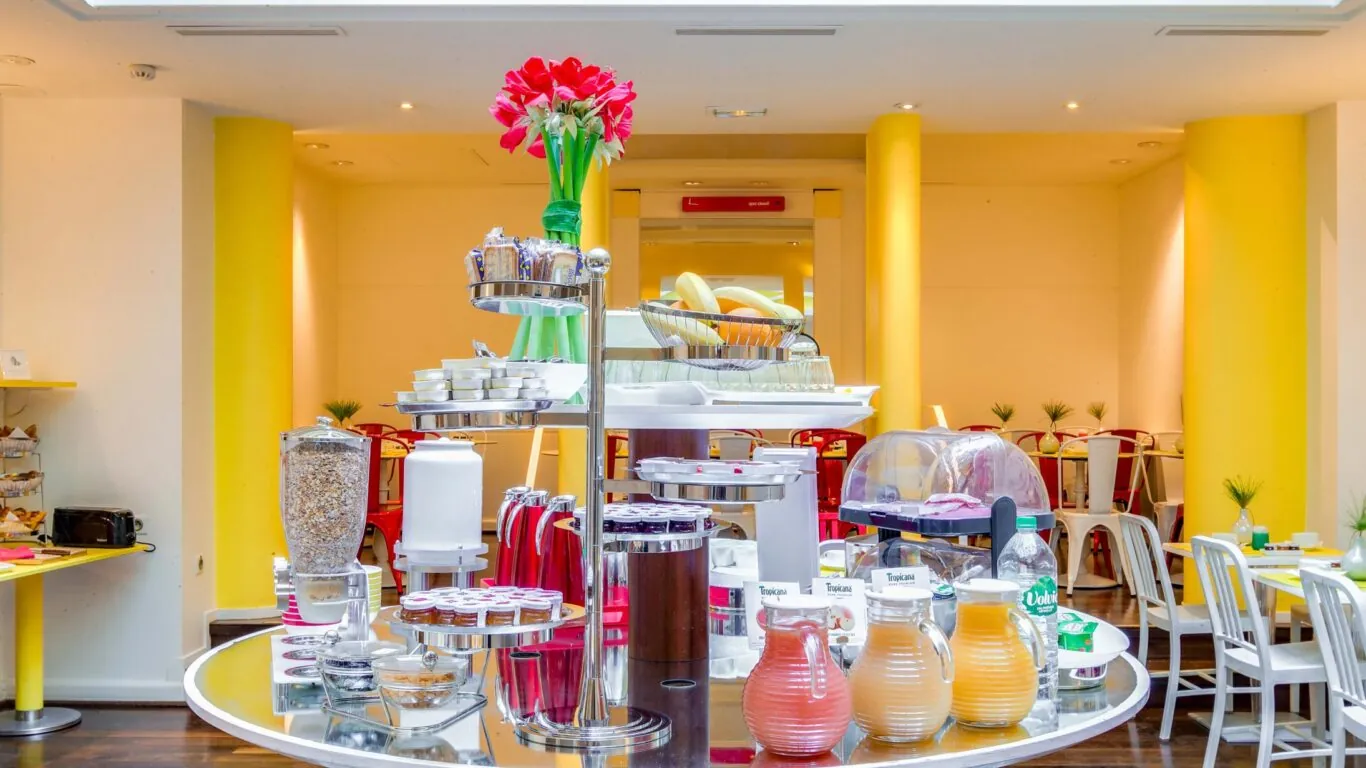 Salle de petit-déjeuner de l’hôtel Astoria à Paris avec buffet varié, ambiance chaleureuse et décor animé.