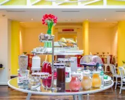 Salle de petit-déjeuner de l’hôtel Astoria à Paris avec buffet varié, ambiance chaleureuse et décor animé.