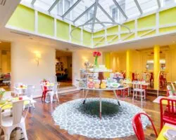 Salle de petit-déjeuner de l’hôtel Astoria à Paris avec buffet varié, ambiance chaleureuse et décor animé.