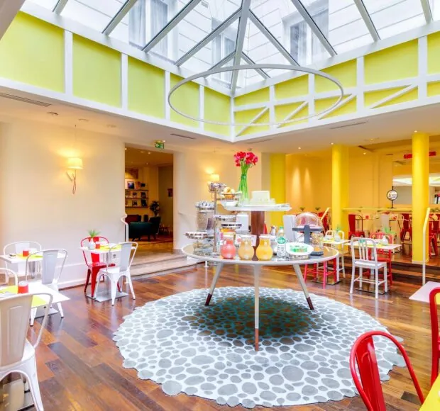 Salle de petit-déjeuner de l’hôtel Astoria à Paris avec buffet varié, ambiance chaleureuse et décor animé.
