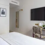 Chambre Double Standard Bouglione avec une chaise à motif zèbre et une télévision à écran plat à l’hôtel Astra Opéra