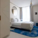 Chambre Double Standard Claudie Haigneré avec un lit et un tapis bleu à l’hôtel Astra Opéra