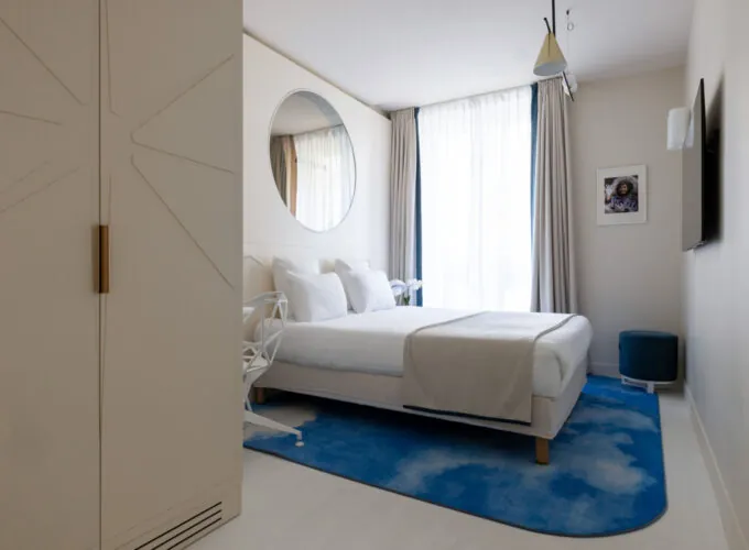 Chambre Double Standard Claudie Haigneré avec un lit et un tapis bleu à l’hôtel Astra Opéra
