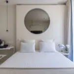 Chambre Double Standard Claudie Haigneré avec un lit et un miroir à l’hôtel Astra Opéra