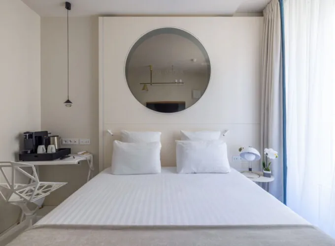 Chambre Double Standard Claudie Haigneré avec un lit et un miroir à l’hôtel Astra Opéra