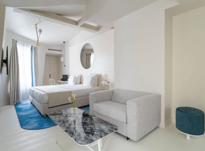 Chambre Exécutive Claudie Haigneré avec un lit, un fauteuil et une table à l’hôtel Astra Opéra