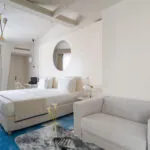 Chambre Exécutive Claudie Haigneré avec un grand lit et un canapé à l’hôtel Astra Opéra