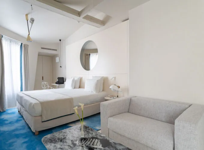 Chambre Exécutive Claudie Haigneré avec un grand lit et un canapé à l’hôtel Astra Opéra