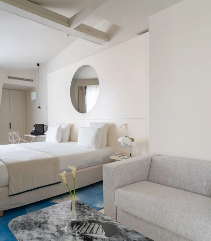 Chambre Exécutive Claudie Haigneré avec un grand lit et un canapé à l’hôtel Astra Opéra