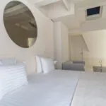 Chambre Exécutive Claudie Haigneré avec un canapé et un miroir au mur à l’hôtel Astra Opéra