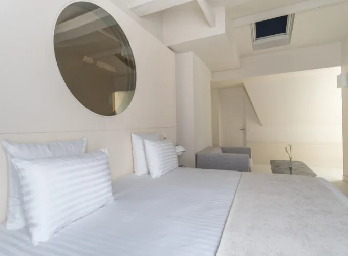 Chambre Exécutive Claudie Haigneré avec un canapé et un miroir au mur à l’hôtel Astra Opéra