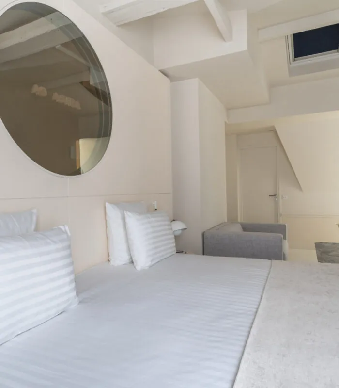 Chambre Exécutive Claudie Haigneré avec un canapé et un miroir au mur à l’hôtel Astra Opéra