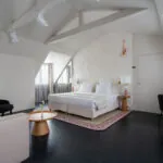 Chambre Exécutive Marie-Agnès Gillot avec un grand lit et un fauteuil à l’hôtel Astra Opéra