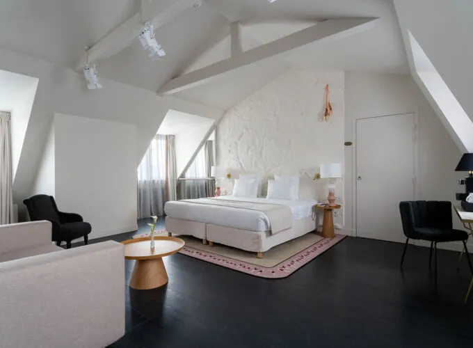 Chambre Exécutive Marie-Agnès Gillot avec un grand lit et un fauteuil à l’hôtel Astra Opéra