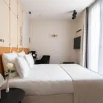 Chambre Familiale Double Terrasse Daniel Auteuil avec un lit et un mur à l’hôtel Astra Opéra