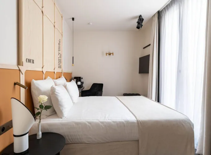 Chambre Familiale Double Terrasse Daniel Auteuil avec un lit et un mur à l’hôtel Astra Opéra