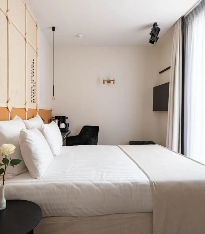 Chambre Familiale Double Terrasse Daniel Auteuil avec un lit et un mur à l’hôtel Astra Opéra