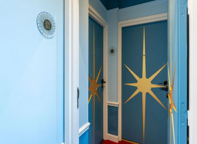 Couloir Familiale Sas Daniel Auteuil avec une porte bleue à l’hôtel Astra Opéra