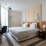 Chambre Familiale Twin Supérieure Daniel Auteuil avec deux lits, un bureau et une télévision à l’hôtel Astra Opéra