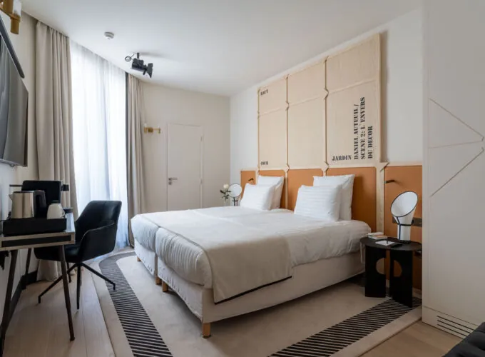 Chambre Familiale Twin Supérieure Daniel Auteuil avec deux lits, un bureau et une télévision à l’hôtel Astra Opéra