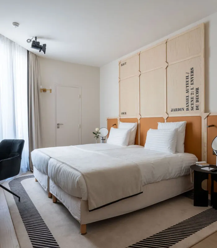 Chambre Familiale Twin Supérieure Daniel Auteuil avec deux lits, un bureau et une télévision à l’hôtel Astra Opéra