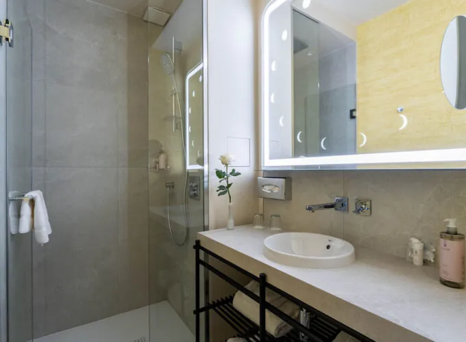 Salle de bain Familiale Twin Supérieure Daniel Auteuil avec un lavabo et une douche à l’italienne à l’hôtel Astra Opéra