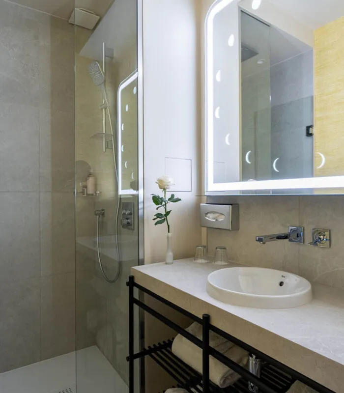Salle de bain Familiale Twin Supérieure Daniel Auteuil avec un lavabo et une douche à l’italienne à l’hôtel Astra Opéra