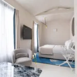 Chambre Triple Claudie Haigneré avec un lit, une chaise et une télévision à l’hôtel Astra Opéra