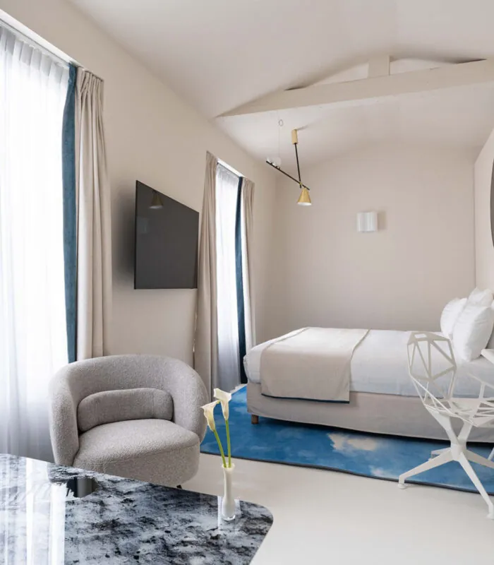 Chambre Triple Claudie Haigneré avec un lit, une chaise et une télévision à l’hôtel Astra Opéra