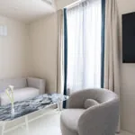 Salon de la chambre Triple Claudie Haigneré avec un canapé et une chaise à l’hôtel Astra Opéra