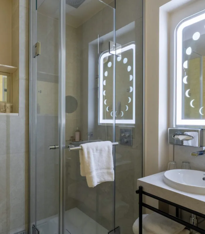 Salle de bain Twin Standard Daniel Auteuil avec un lavabo, un miroir et une douche à l’hôtel Astra Opéra