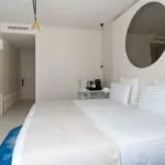 Chambre Twin Supérieure Claudie Haigneré avec un lit et un miroir rond à l’hôtel Astra Opéra