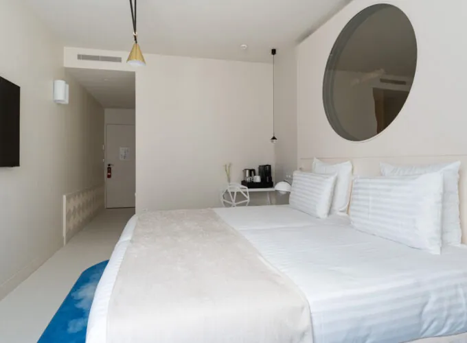 Chambre Twin Supérieure Claudie Haigneré avec un lit et un miroir rond à l’hôtel Astra Opéra