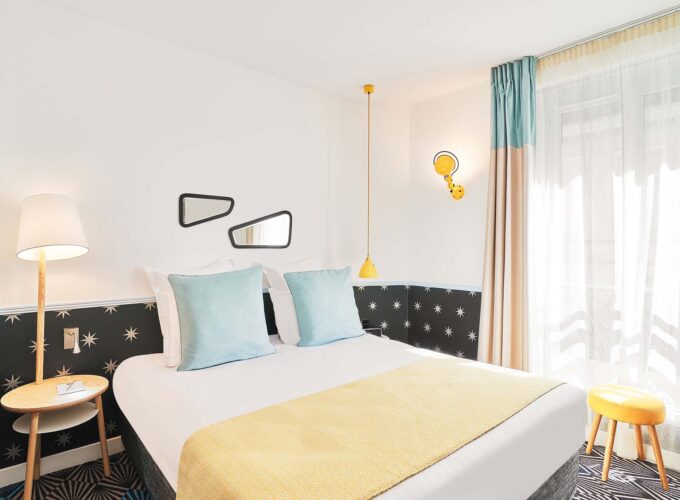 Chambre Double avec un lit et deux miroirs au mur à l’hôtel Augustin