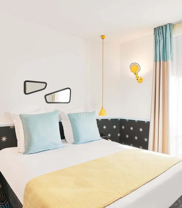 Chambre Double avec un lit et deux miroirs au mur à l’hôtel Augustin