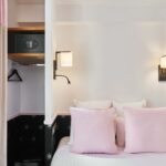 Chambre Double avec un coffre-fort et un lit avec des oreillers roses à l’hôtel Augustin