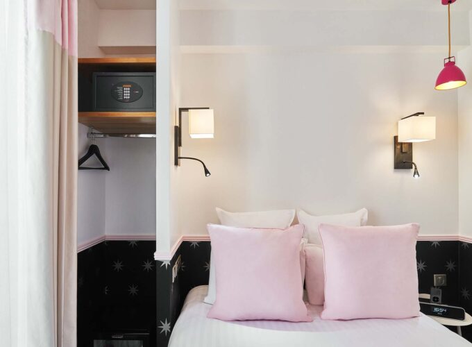 Chambre Double avec un coffre-fort et un lit avec des oreillers roses à l’hôtel Augustin