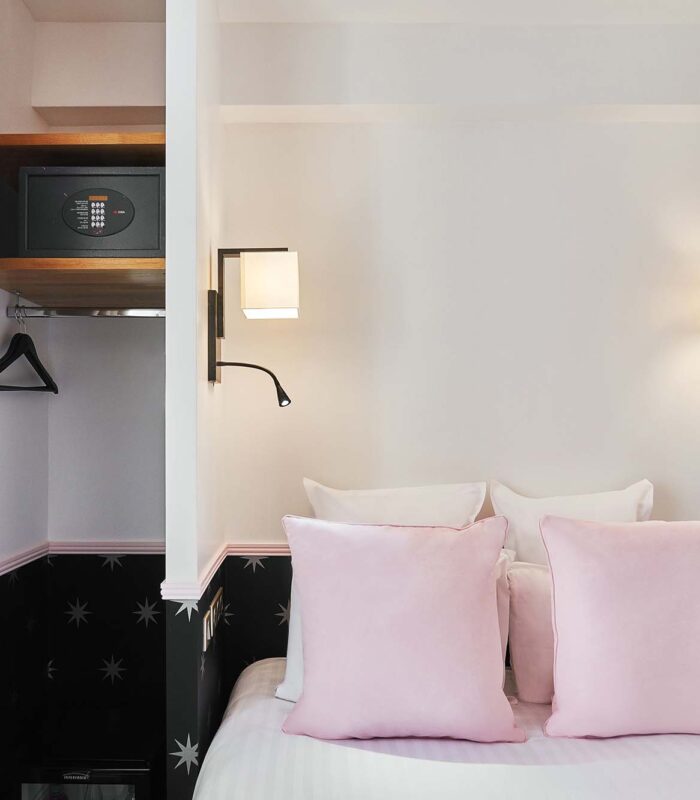 Chambre Double avec un coffre-fort et un lit avec des oreillers roses à l’hôtel Augustin