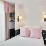 Chambre Double avec un lit et un réveil rose à l’hôtel Augustin