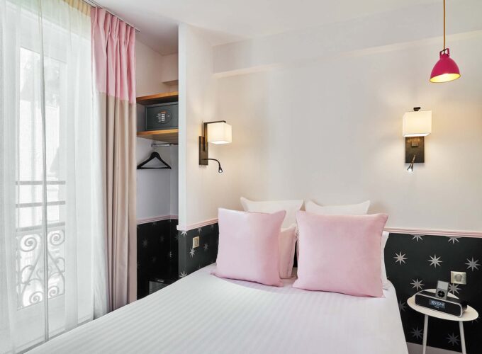 Chambre Double avec un lit et un réveil rose à l’hôtel Augustin