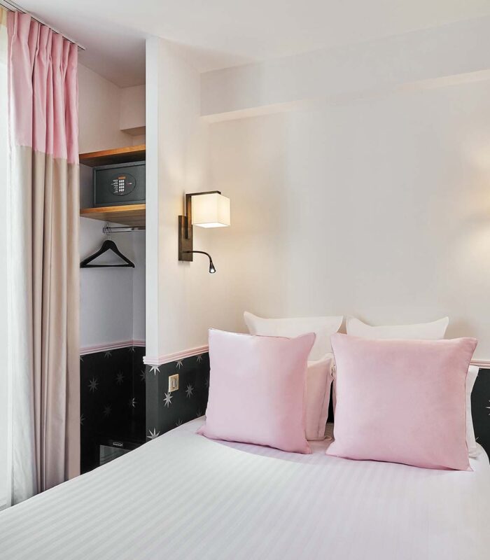 Chambre Double avec un lit et un réveil rose à l’hôtel Augustin
