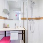 Chambre Double, salle de bains avec un lavabo, un miroir et une douche à l’hôtel Augustin