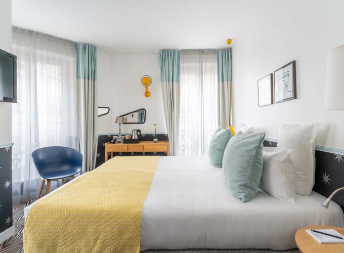 Chambre Familiale avec un grand lit et une chaise bleue à l’hôtel Augustin