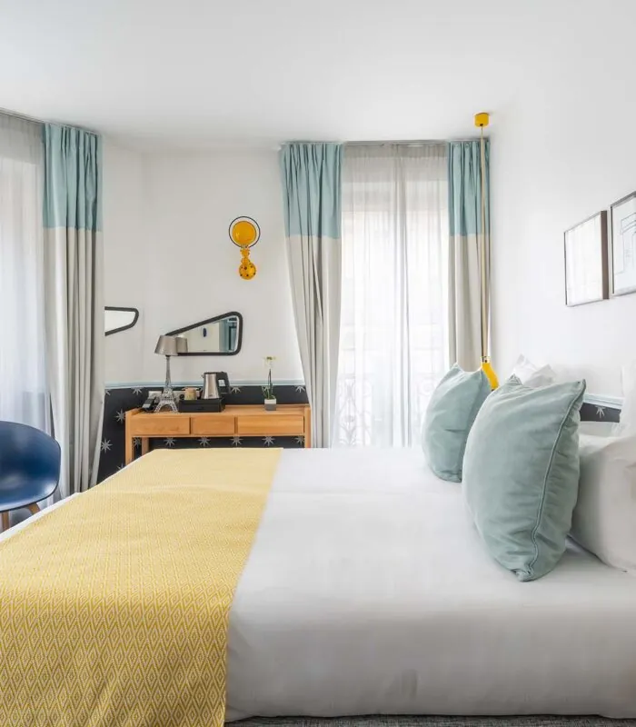 Chambre Familiale avec un grand lit et une chaise bleue à l’hôtel Augustin