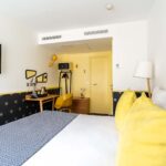 Chambre Familiale avec un lit, un bureau et une télévision à écran plat à l’hôtel Augustin