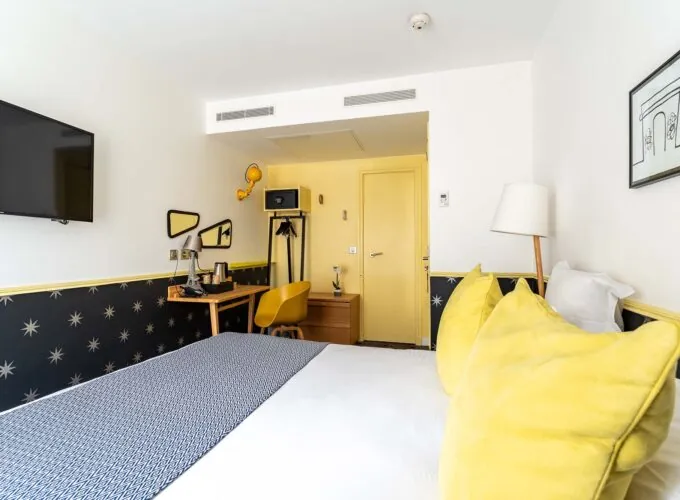 Chambre Familiale avec un lit, un bureau et une télévision à écran plat à l’hôtel Augustin